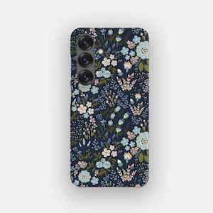 May include: A dark navy blue smartphone case featuring a repeating pattern of small flowers and leaves in shades of light blue, soft pink, and olive green. The case includes a vertical camera module with three circular lenses on the upper left side.