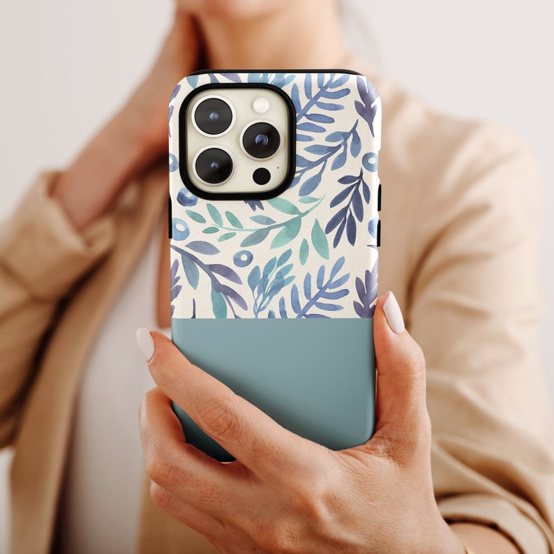 a woman holding a phone case with a floral pattern