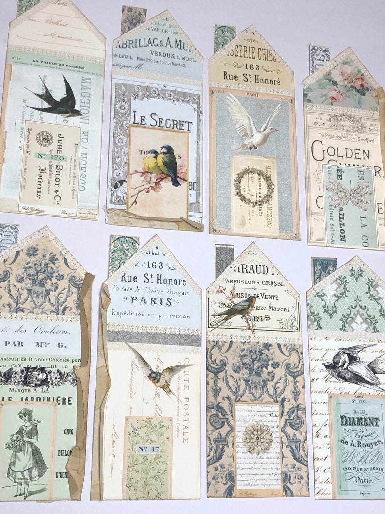 May include: A collection of vintage-style paper ephemera with a variety of designs, including birds, flowers, and text. The paper is in shades of cream, blue, and green. The text includes the words "Le Secret", "Golden", "Diamant", and "163 Rue S! Honor&eacute;".