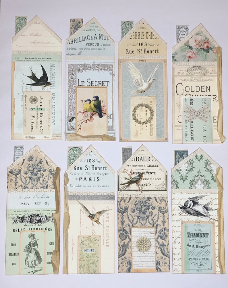 May include: A collection of vintage paper ephemera with a variety of designs, including birds, flowers, and text. The papers are in shades of blue, green, and white, and have a distressed, aged look.