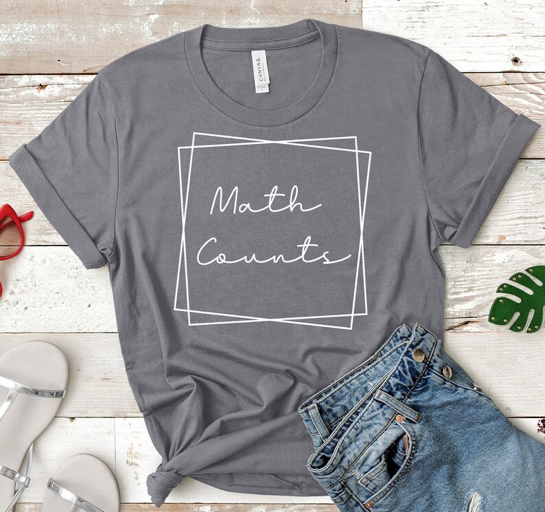 Op de afbeelding: Grijs T-shirt met witte tekst die "Math Counts" zegt in een wit kader.