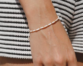 Bracciale con perline tubolari in madreperla: dettagli dorati, gioielli regolabili