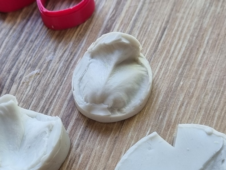 以下が含まれることがあります： 樹脂工芸品を作るための白いシリコンモールド3つ。モールドは葉っぱや丸い形など、さまざまな形をしています。