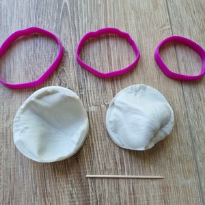 Puede incluir: Tres moldes de silicona rosa para hacer pétalos de rosa, dos son redondos y uno tiene forma de pétalo de rosa, y un pincho de madera.