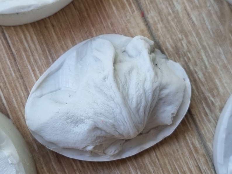 May include: A white silicone mold shaped like a flower bud, with a textured surface.