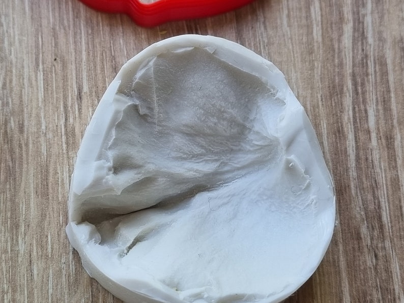 May include: A white silicone mold with a textured surface. The mold is shaped like a leaf.