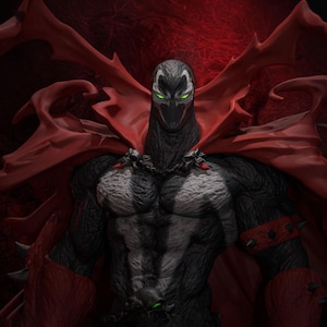 May include: A detailed Spawn action figure featuring a muscular black textured suit with white chest markings, a flowing red cape, spiked red wrist gauntlets, and skull-adorned shoulder armor. The character has a masked face with glowing green eyes.