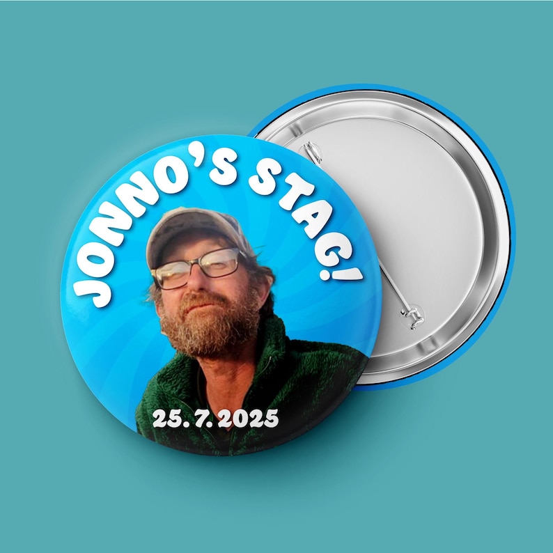 May include: A circular pin-back button featuring a photograph of a bearded person wearing glasses and a cap. The blue background includes the white text JONNO'S STAG! and the date 25. 7. 2025. The back of the button shows a metal pin mechanism.
