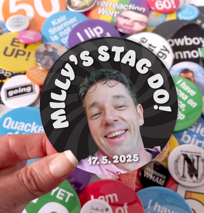 May include: A circular pinback button featuring a photograph of a smiling person. The background has a black and gray spiral pattern. The text "MILLY'S STAG DO!" is printed in white at the top, and the date "17. 5. 2025" is printed in white at the bottom.