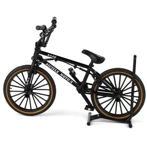 Op de afbeelding: Een zwart BMX-fietsmodel met bruine banden en de tekst "RACE" en "BICYCLE MOTO-X" op het frame. Het model wordt op een zwarte standaard gepresenteerd. De fiets heeft een zwart zadel en stuur.