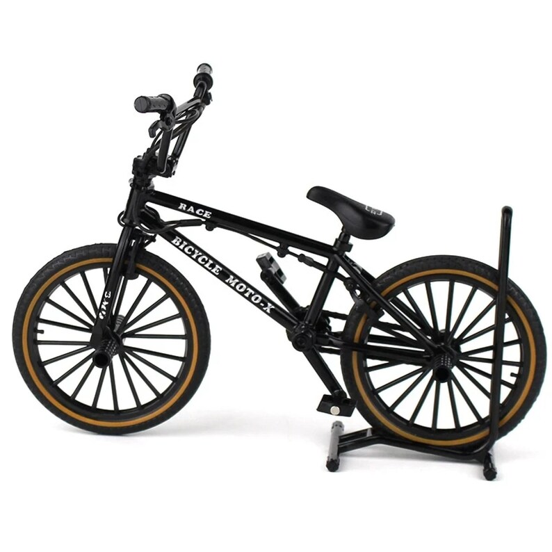 Op de afbeelding: Een zwart BMX-fietsmodel met bruine banden en de tekst "RACE" en "BICYCLE MOTO-X" op het frame. Het model wordt op een zwarte standaard gepresenteerd. De fiets heeft een zwart zadel en stuur.
