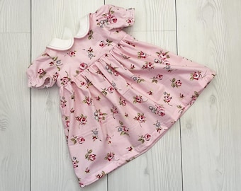 Vestito da bambina rosa a fiori, colletto Peter Pan, maniche corte.