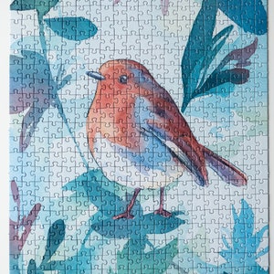 May include: A watercolor jigsaw puzzle featuring a robin perched on a branch surrounded by blue and green leaves.