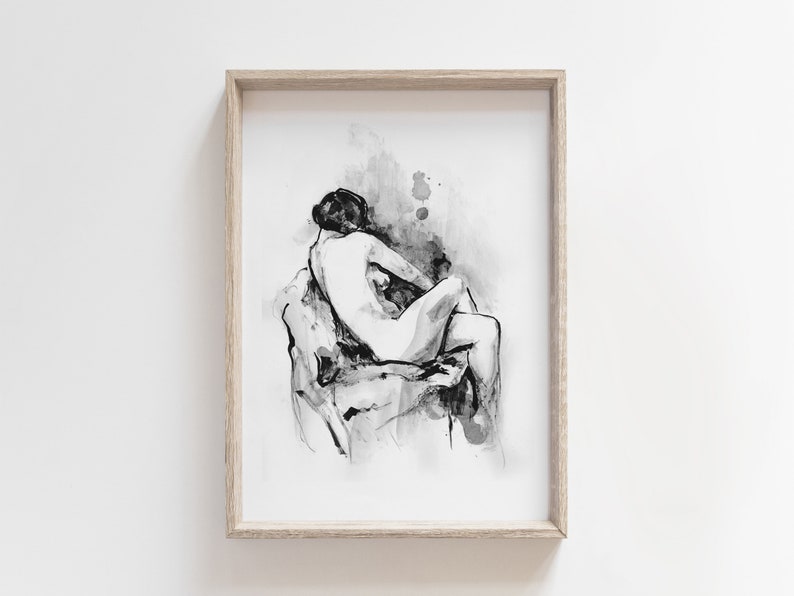 May include: Black and white ink drawing of a nude figure sitting on a rock. The drawing is framed in a light wood frame.