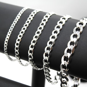 May include: Four silver curb chain necklaces of varying widths displayed on a black surface.