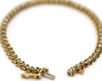 May include: A gold and silver diamond tennis bracelet. The bracelet is made of a delicate chain with small diamonds set in a pave setting.