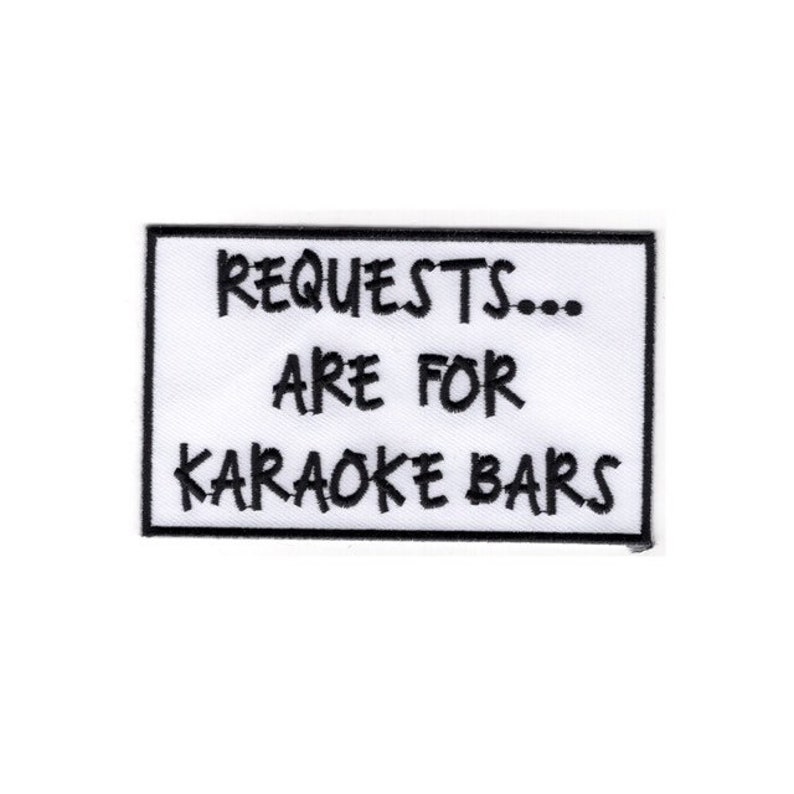 K&ouml;nnte beinhalten: Wei&szlig;er rechteckiger Patch mit schwarzem gesticktem Text, der "REQUESTS... ARE FOR KARAOKE BARS" lautet.