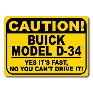 May include: Yellow and black caution sign with the text "CAUTION! BUICK MODEL D-34 YES IT'S FAST, NO YOU CAN'T DRIVE IT!"