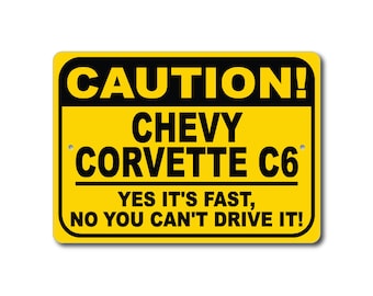Könnte beinhalten: Ein gelbes und schwarzes Warnschild mit dem Text "CAUTION! CHEVY CORVETTE C6 YES IT'S FAST, NO YOU CAN'T DRIVE IT!"