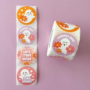 Pode incluir: Um rolo de adesivos redondos com um design de fantasma e flores. Os adesivos t&ecirc;m frases diferentes, incluindo "Obrigado Boo!" e "Fique assustador".
