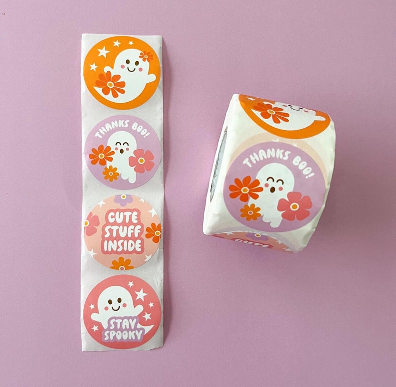 Pode incluir: Um rolo de adesivos redondos com um design de fantasma e flores. Os adesivos t&ecirc;m frases diferentes, incluindo "Obrigado Boo!" e "Fique assustador".