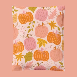 May include: A white background with a repeating pattern of orange and pink pumpkins with brown stems and green leaves. The pumpkins are outlined in brown and have a stylized design.