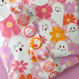 Pode incluir: Envelopes de envio com padr&otilde;es rosa e branco com adesivos coloridos com fantasmas e flores. Os adesivos dizem "Obrigado Boo!" "Coisas fofas dentro" e "Fique assustador".