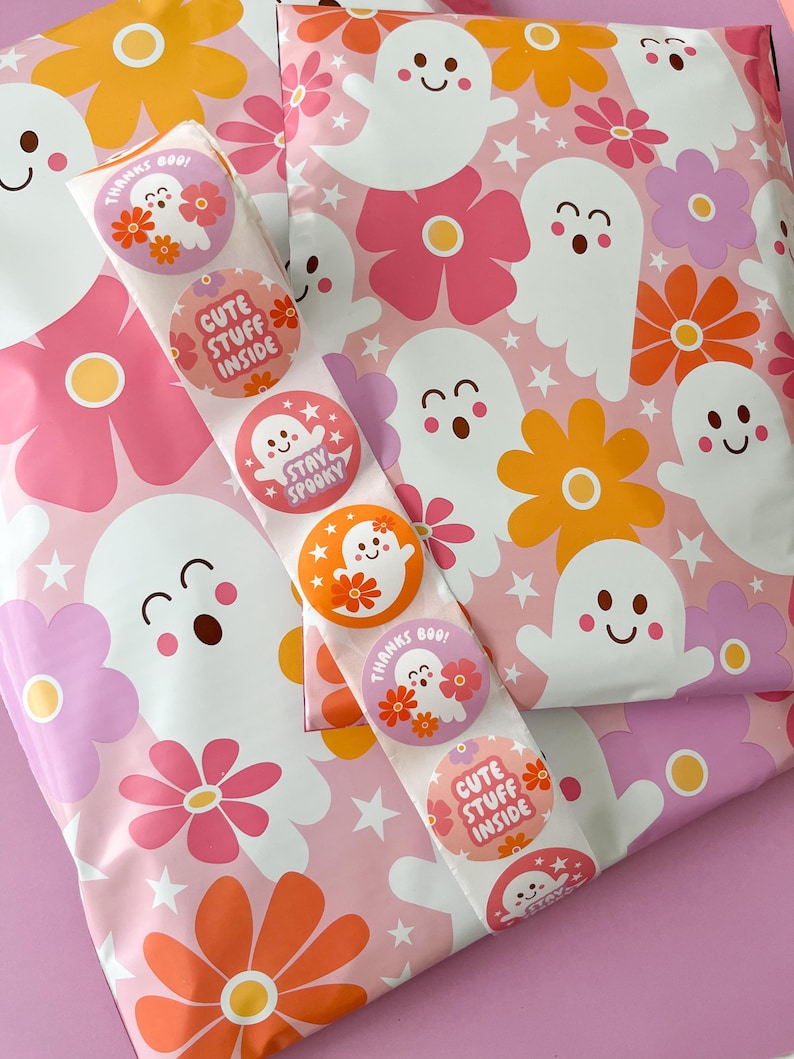 Pode incluir: Envelopes de envio com padr&otilde;es rosa e branco com adesivos coloridos com fantasmas e flores. Os adesivos dizem "Obrigado Boo!" "Coisas fofas dentro" e "Fique assustador".