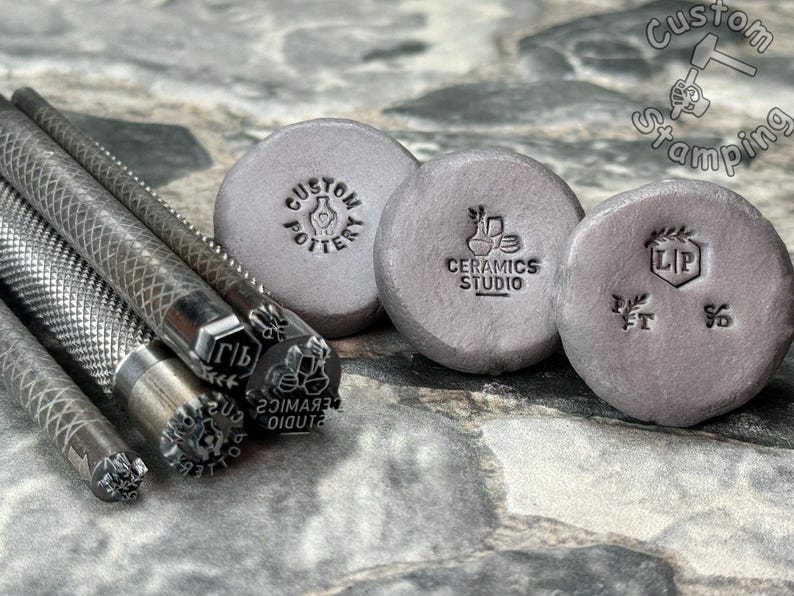 May include: A set of metal stamps for creating custom designs on pottery, ceramics, and other surfaces. The stamps feature various designs, including a hand holding a pot, a vase with flowers, a leaf, and the letters "LP".