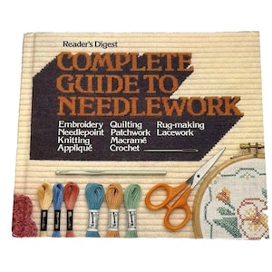 May include: A vintage "Reader's Digest Complete Guide to Needlework" book with embroidery supplies. The cover features text and a graphic. Includes embroidery floss, scissors, a needle, and a wooden embroidery hoop.