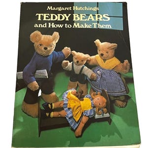 May include: A hardcover book titled TEDDY BEARS and How to Make Them by Margaret Hutchings. The cover features three teddy bears and a doll lying in a small bed. The bears wear knitted clothing, and the doll wears a yellow and blue dress.