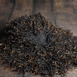 Puede incluir: Una alfombra de piel de oveja marr&oacute;n y negra esponjosa con una textura suave y rizada. La alfombra es perfecta para agregar un toque de calidez y comodidad a cualquier habitaci&oacute;n.