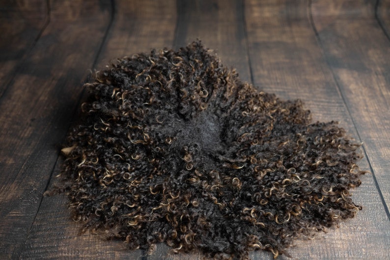 Puede incluir: Una alfombra de piel de oveja marr&oacute;n y negra esponjosa con una textura suave y rizada. La alfombra es perfecta para agregar un toque de calidez y comodidad a cualquier habitaci&oacute;n.