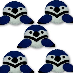 Peut inclure: Cinq ornements en feutre en forme de geais bleus, avec le ventre blanc, un bec noir et de petits yeux en bouton. Les oiseaux ont les ailes déployées et sont disposés sur un fond blanc. Ces ornements faits à la main sont parfaits pour un sapin de Noël sur le thème de la nature.