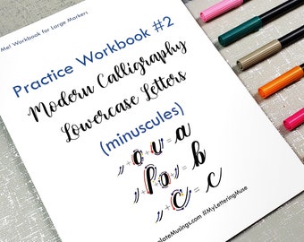 May include: A white sheet of paper with the title "Practice Workbook #2 Modern Calligraphy Lowercase Letters (minuscules)" and instructions for writing the letters "a", "b", and "c" in a modern calligraphy style. The paper is surrounded by colorful markers.