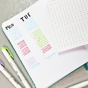 May include: A close-up of a planner with a weekly schedule. The planner has a dotted grid and is filled with colorful sticky notes with handwritten text. The text on the sticky notes includes "Sleep", "Class", "Work", and "Class".