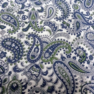 Puede incluir: Tela blanca con un patrón de paisley en tonos azules y verdes.