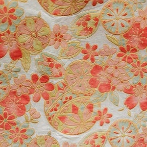 May include: Close-up of a fabric with a repeating floral pattern. The design features stylized flowers and leaves in shades of coral, peach, yellow, and light blue against a white background. The fabric has a textured appearance.