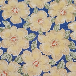 May include: A blue fabric with a repeating pattern of yellow flowers. The flowers have a light brown center and are surrounded by green leaves.