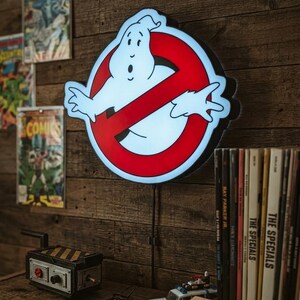 May include: A circular LED wall sign featuring the iconic white ghost character centered within a red circle with a diagonal slash. The sign emits a bright glow, showcasing the classic film logo design with clean lines and a smooth, illuminated surface.