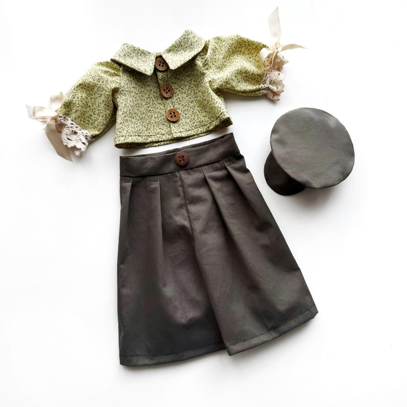 May include: A green and white floral print blouse with a brown button closure, a gray skirt with pleats, and a gray hat.