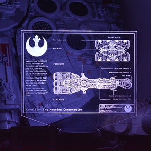 Könnte beinhalten: Ein weiß-blaues Diagramm eines Raumschiffs, der CR90 Corvette, mit dem Text "Corellian Engineering Corporation" und "CR90 Corvette". Das Diagramm zeigt die Seitenansicht und die Vorderansicht des Raumschiffs.
