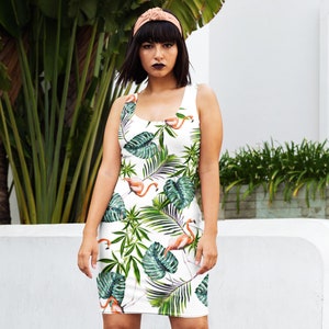 May include: A white sleeveless dress with a tropical print featuring pink flamingos and green palm leaves.