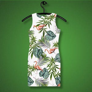 May include: White sleeveless dress with a tropical print featuring pink flamingos and green palm leaves.