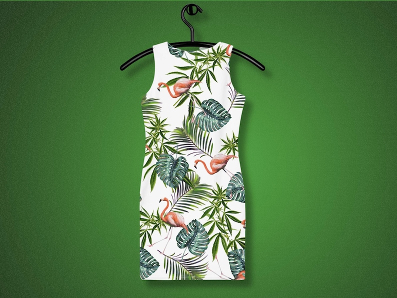 May include: White sleeveless dress with a tropical print featuring pink flamingos and green palm leaves.
