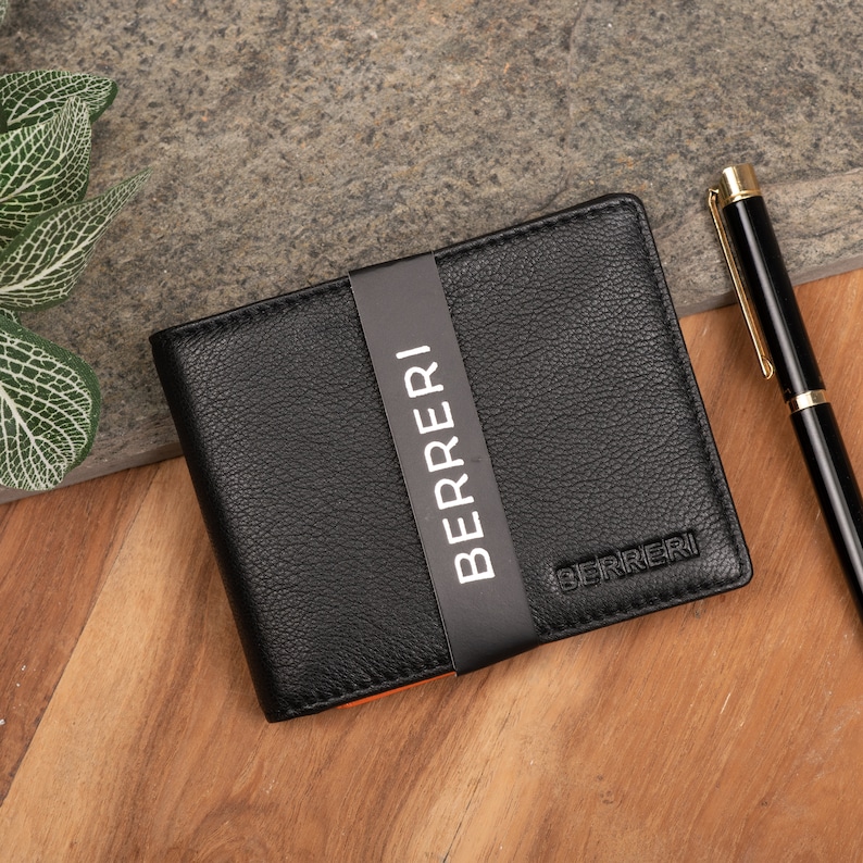May include: A black leather wallet with a black and white label that says "BERRERI".
