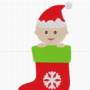 May include: A red and green Christmas stocking with a white snowflake design. A baby wearing a red Santa hat is peeking out of the top of the stocking.