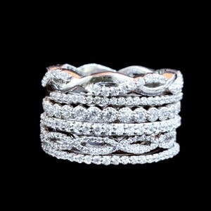 Peut inclure: Un ensemble de sept bagues en argent avec différents motifs de diamants. Les bagues sont empilées les unes sur les autres, créant un look unique et élégant.