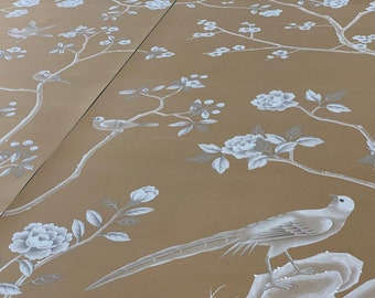 May include: Wallpaper featuring a tan background with a repeating pattern of white flowering branches and birds. The design includes detailed illustrations of various birds perched on thin, winding tree limbs surrounded by blooming flowers.