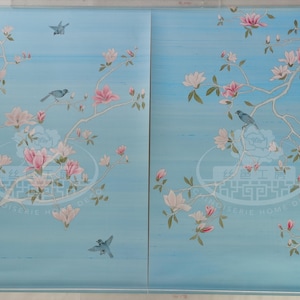 May include: Two panels of blue wallpaper with a white floral design and small blue birds. The wallpaper features a repeating pattern of magnolia blossoms and leaves.